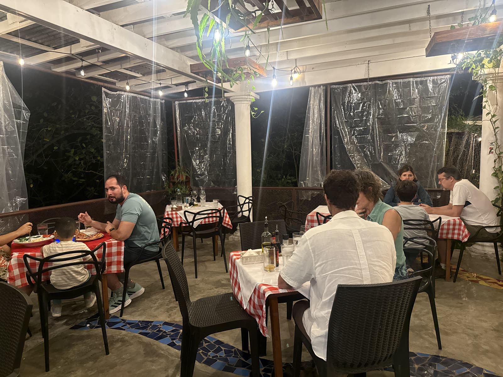 Terraza real de La Divina Commedia El Valle — mantel a cuadros y luces cálidas